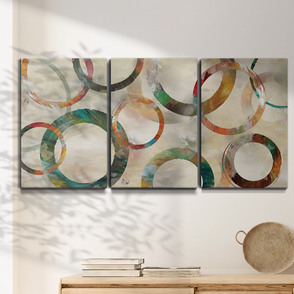 Three-panel canvas wall art featuring geometric circular abstract design, displayed in a minimalist living room above a console table.