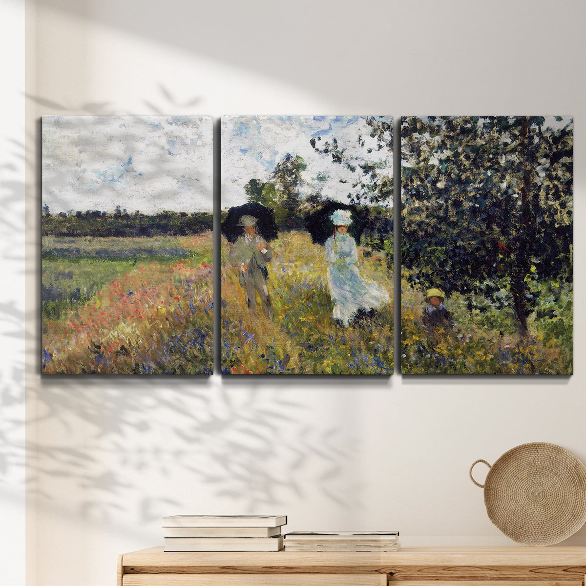 Three-panel canvas wall art featuring figures walking along riverbank, displayed in a minimalist living room above a console table.