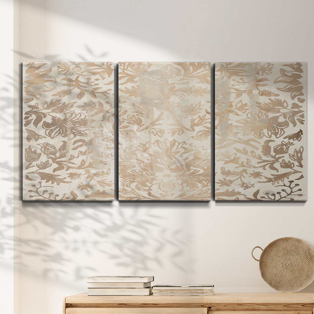 Three-panel canvas wall art featuring ornamental damask abstract pattern, displayed in a minimalist living room above a console table.
