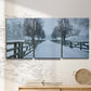 Three-panel canvas wall art featuring snow covered rural road photograph, displayed in a minimalist living room above a console table.