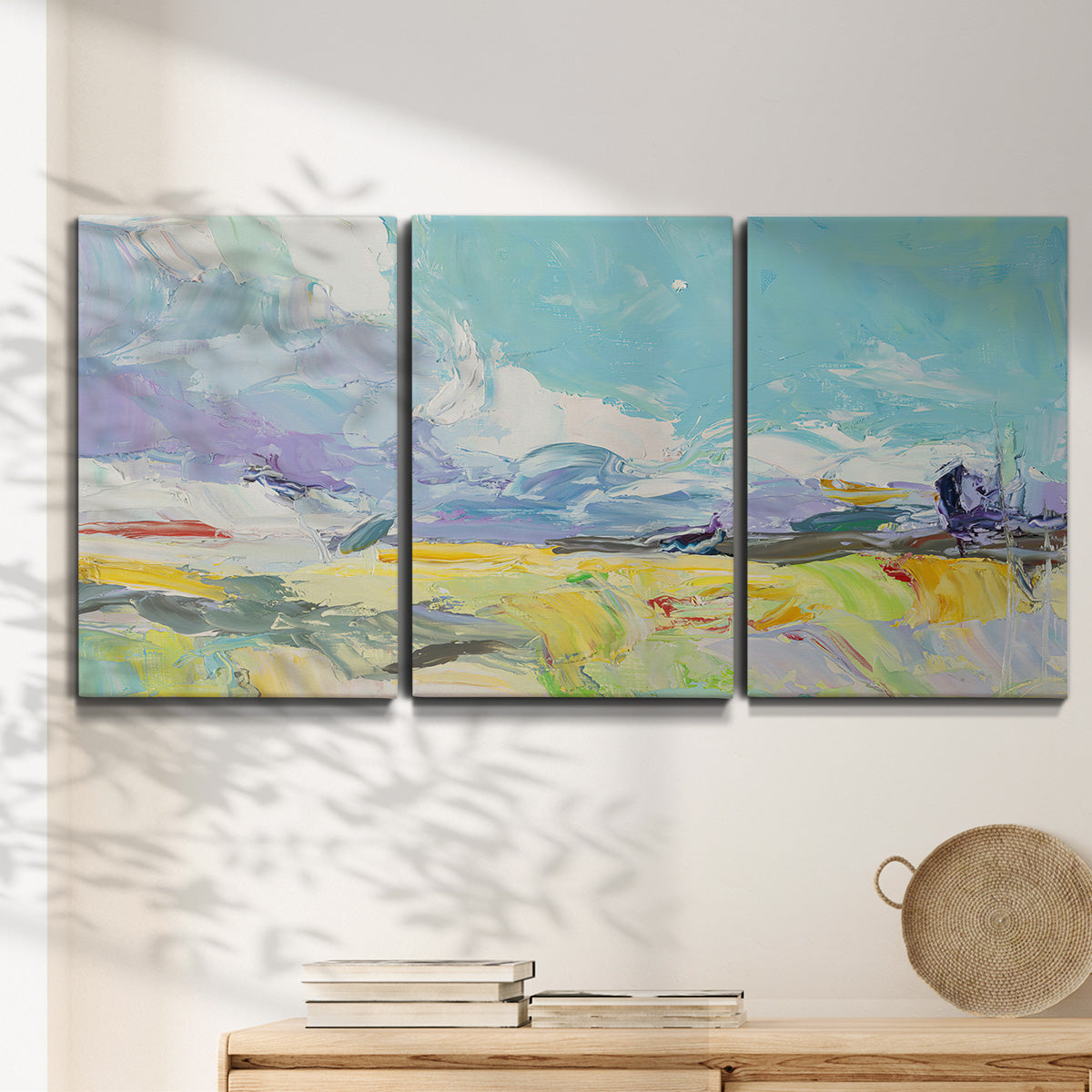 Three-panel canvas wall art featuring open landscape suggesting distant journey, displayed in a minimalist living room above a console table.