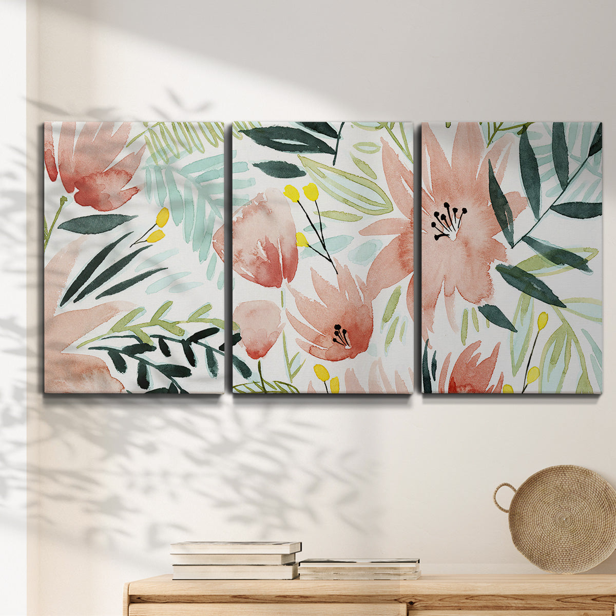 Three-panel canvas wall art featuring layered tropical plant collage, displayed in a minimalist living room above a console table.