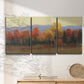 Three-panel canvas wall art featuring autumn landscape changing foliage, displayed in a minimalist living room above a console table.