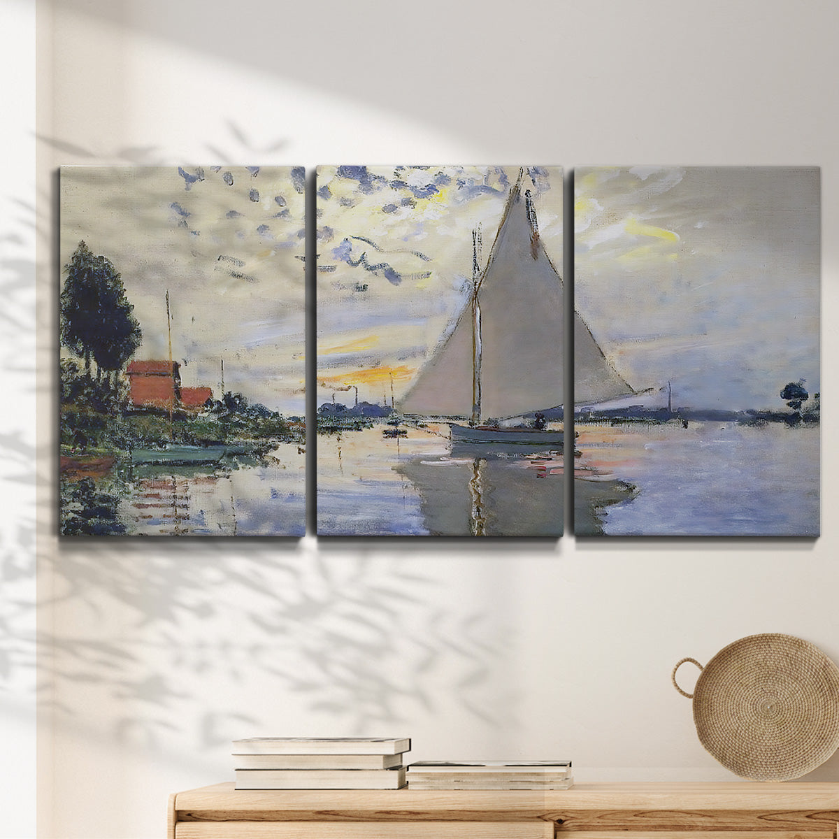 Three-panel canvas wall art featuring riverside village shoreline, displayed in a minimalist living room above a console table.