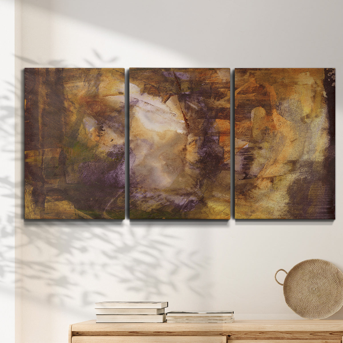 Three-panel canvas wall art featuring abstract architectural landscape, displayed in a minimalist living room above a console table.