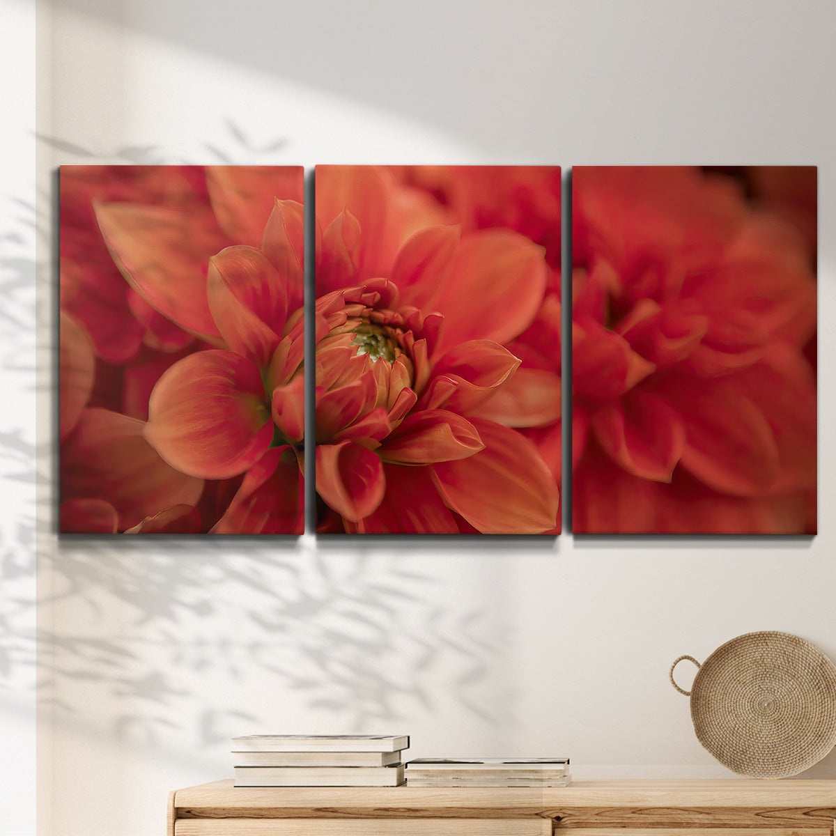 Three-panel canvas wall art featuring vivid red floral close up, displayed in a minimalist living room above a console table.