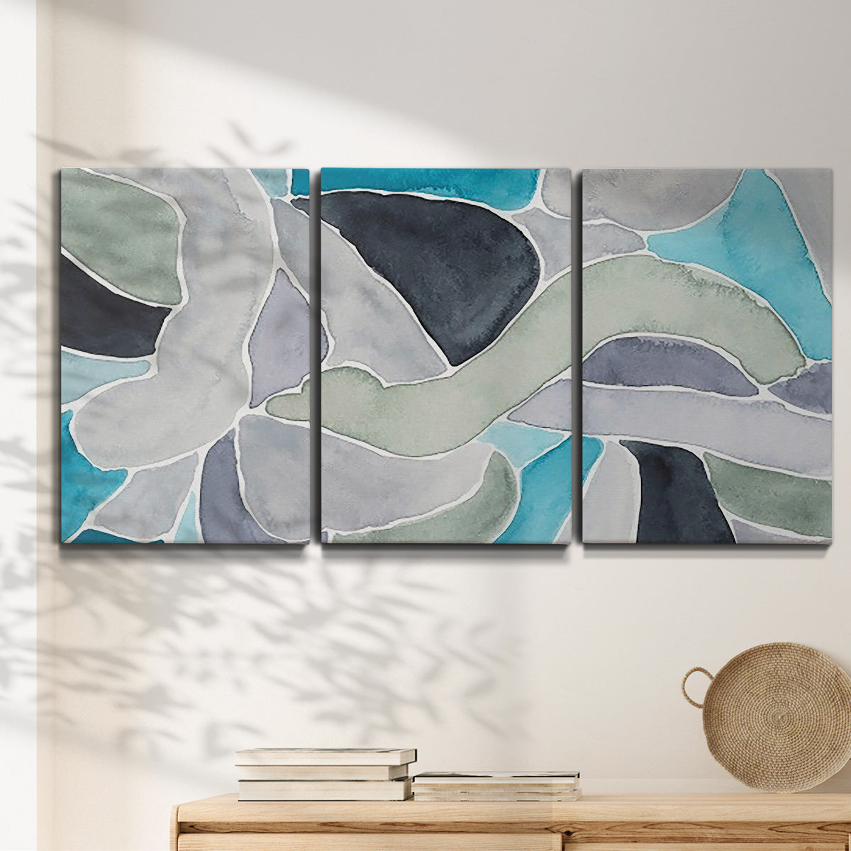 Three-panel canvas wall art featuring subtle abstract billowing color layers, displayed in a minimalist living room above a console table.