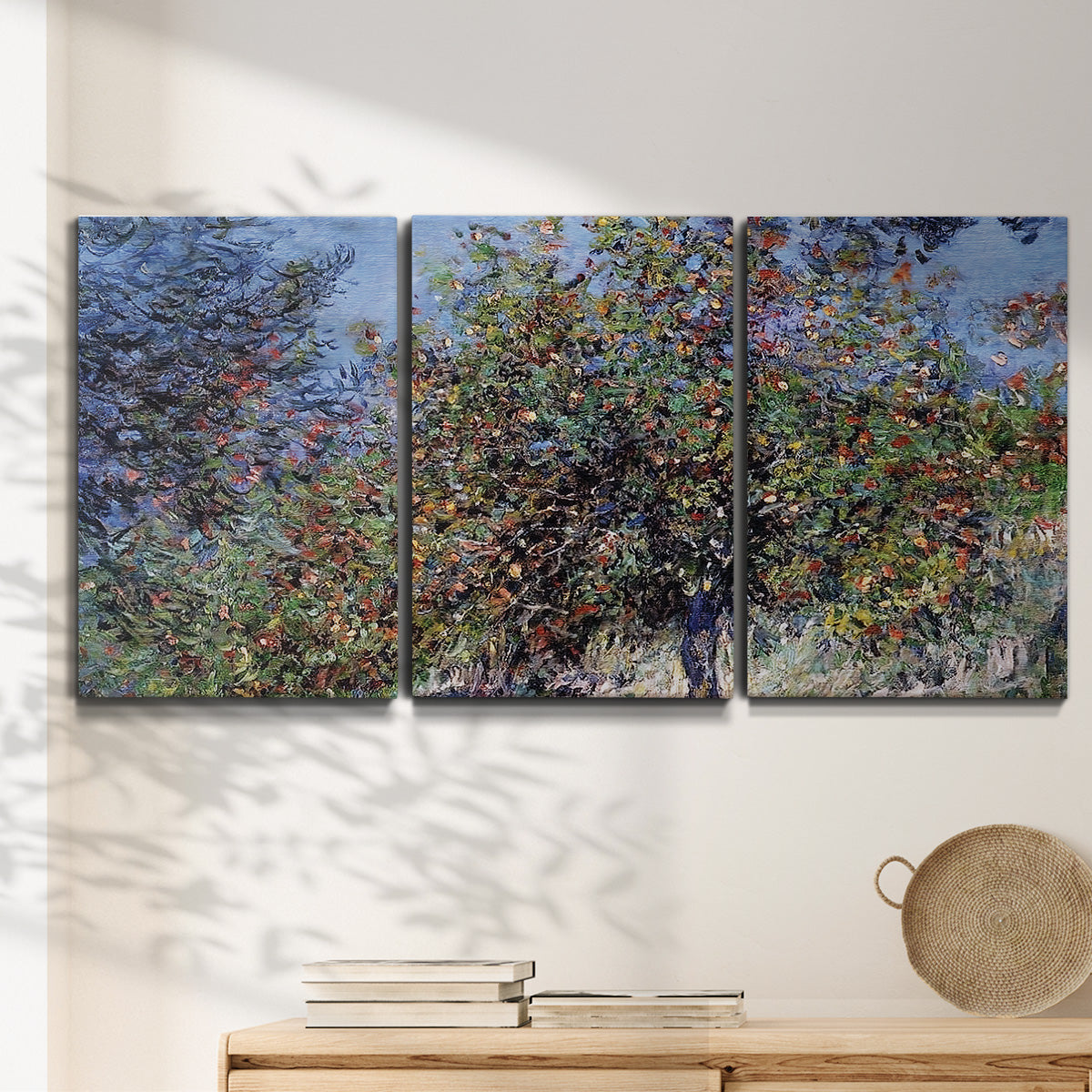 Three-panel canvas wall art featuring orchard of trees in spring bloom, displayed in a minimalist living room above a console table.