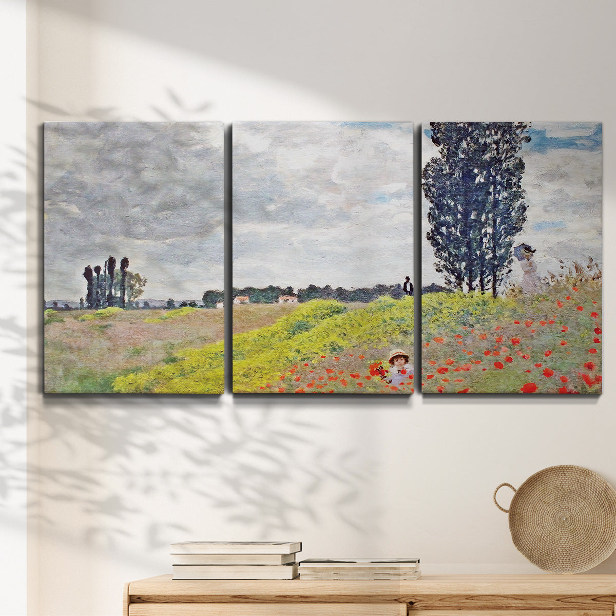 Three-panel canvas wall art featuring open poppy field in countryside, displayed in a minimalist living room above a console table.