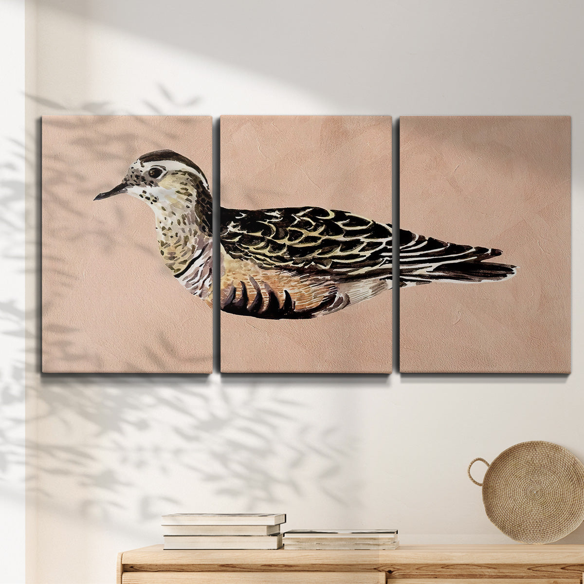 Three-panel canvas wall art featuring coastal bird illustration, displayed in a minimalist living room above a console table.