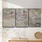 Three-panel canvas wall art featuring early spring blossoms in soft tones, displayed in a minimalist living room above a console table.