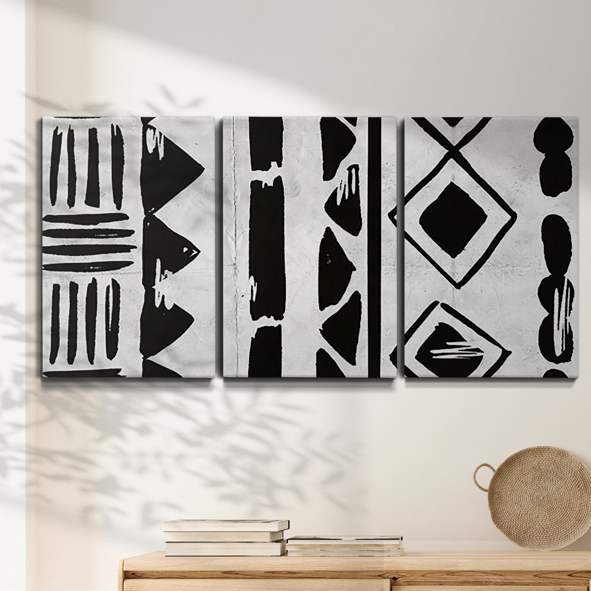 Three-panel canvas wall art featuring geometric abstract forms merging pattern, displayed in a minimalist living room above a console table.