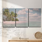Three-panel canvas wall art featuring tropical sand dunes with palms, displayed in a minimalist living room above a console table.