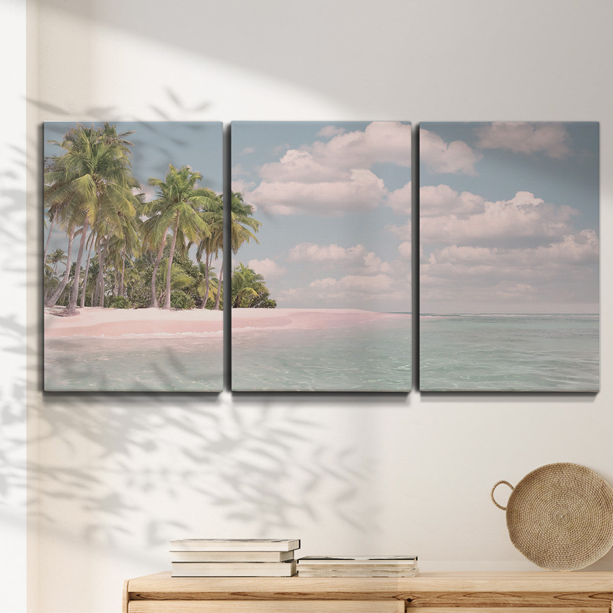 Three-panel canvas wall art featuring tropical sand dunes with palms, displayed in a minimalist living room above a console table.
