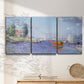 Three-panel canvas wall art featuring river flowing past riverside town, displayed in a minimalist living room above a console table.