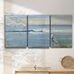 Three-panel canvas wall art featuring sunrise reflecting across bay waters, displayed in a minimalist living room above a console table.