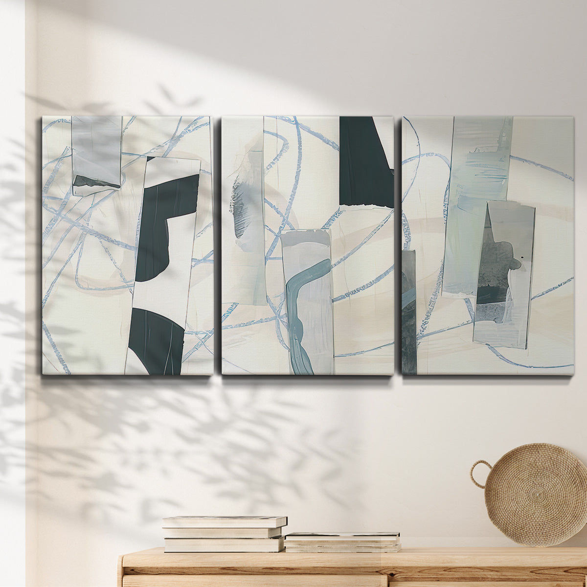 Three-panel canvas wall art featuring interwoven icy abstract linear forms, displayed in a minimalist living room above a console table.