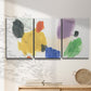 Three-panel canvas wall art featuring inkblot style abstract color symmetry, displayed in a minimalist living room above a console table.