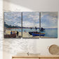 Three-panel canvas wall art featuring busy beach scene with shoreline, displayed in a minimalist living room above a console table.