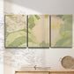 Three-panel canvas wall art featuring minimal verdant floral abstraction, displayed in a minimalist living room above a console table.