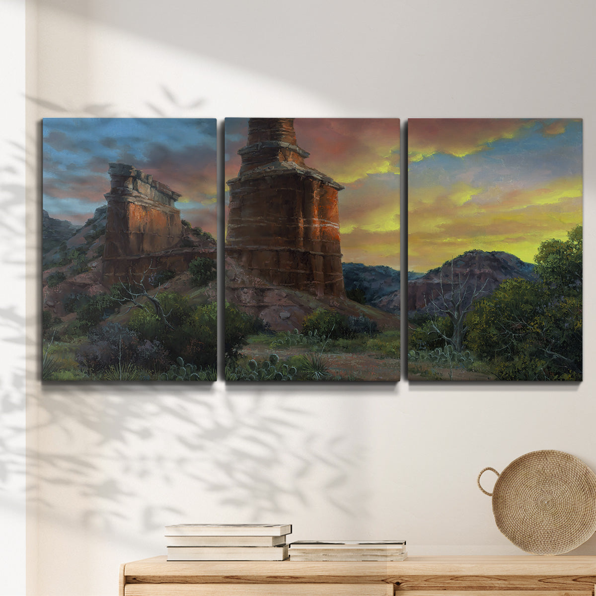 Three-panel canvas wall art featuring dramatic canyon landscape at dusk, displayed in a minimalist living room above a console table.