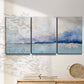 Three-panel canvas wall art featuring abstract bay with rhythmic forms, displayed in a minimalist living room above a console table.