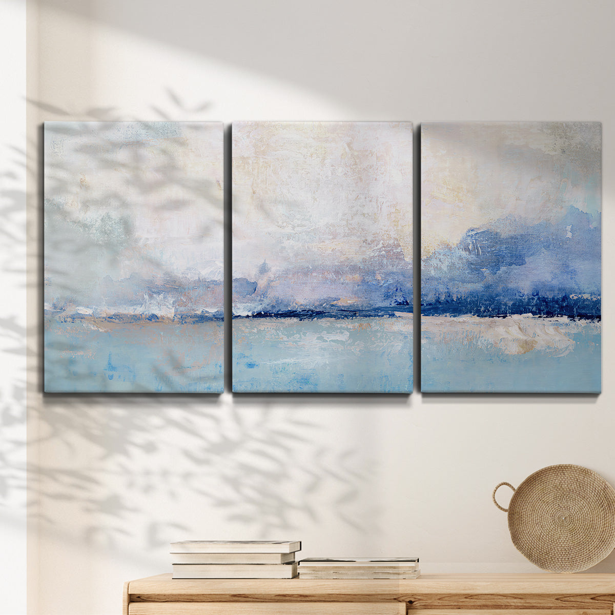 Three-panel canvas wall art featuring abstract bay with rhythmic forms, displayed in a minimalist living room above a console table.