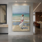 Canvas art print of an impressionist beach scene of a woman in flowing dress in strong wind displayed as a statement piece in a spacious interior.
