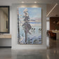 Canvas art print of a winter lakeside scene with figures skating on a frozen lake near snowy trees displayed as a statement piece in a spacious interior.
