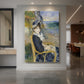 Canvas art print of an impressionist portrait of a woman seated by the sea with soft light displayed as a statement piece in a spacious interior.