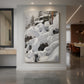 Canvas art print of a snowy wilderness with rocks and trees forming a hidden animal den displayed as a statement piece in a spacious interior.