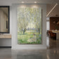 Canvas art print of an impressionist scene of a woman seated beneath willow trees in soft light displayed as a statement piece in a spacious interior.