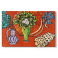 Canvas art print portraying magnolia flowers arranged in a vase within a patterned still life, set against a white background