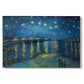 Canvas art print portraying a night scene with glowing stars reflected in river beside illuminated town, set against a white background