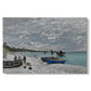 Canvas art print portraying a seaside promenade with figures, flags, and boats along the coast, set against a white background