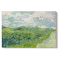 Canvas art print portraying a vivid green wheat field stretching across rolling landscape under pale sky, set against a white background