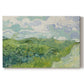 Canvas art print portraying a vivid green wheat field stretching across rolling landscape under pale sky, set against a white background