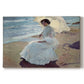 Canvas art print portraying a woman seated on beach in flowing white dress beside water, set against a white background