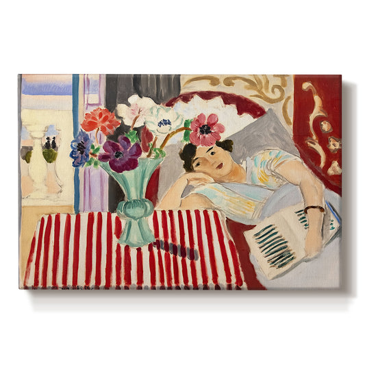 Canvas art print portraying a seated woman beside vase of anemones in richly patterned interior, set against a white background