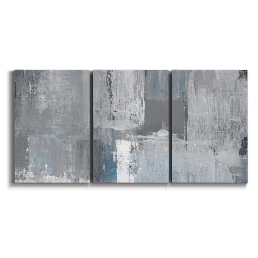 Three-panel canvas wall art featuring cool toned industrial abstract blues on white background.