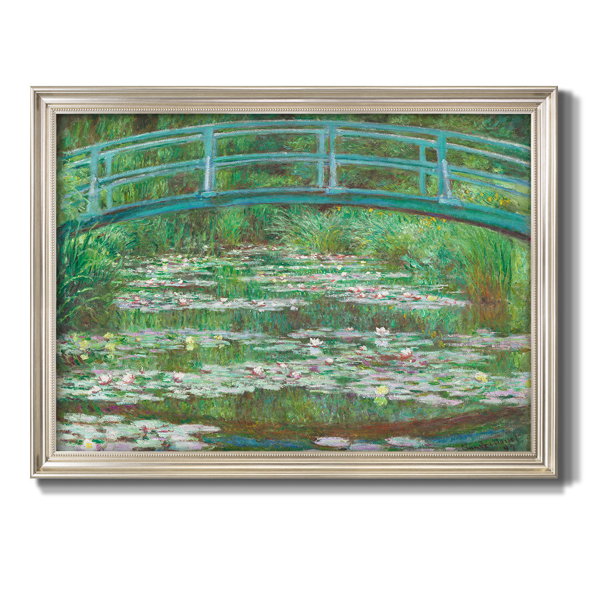 Impressionist garden scene with Japanese bridge and water lilies by Claude Monet printed on canvas in an ornate champagne frame.