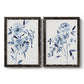 Set of two black barnwood framed canvas prints featuring two expressive watercolor botanical paintings featuring loose blue flowers and leafy branches.