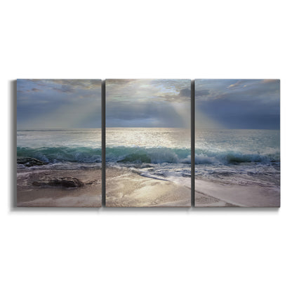 Three-panel canvas wall art featuring soft sunrise over open water on white background.