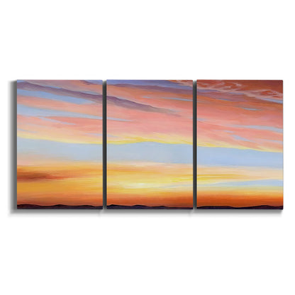Three-panel canvas wall art featuring glowing sunset sky over landscape on white background.