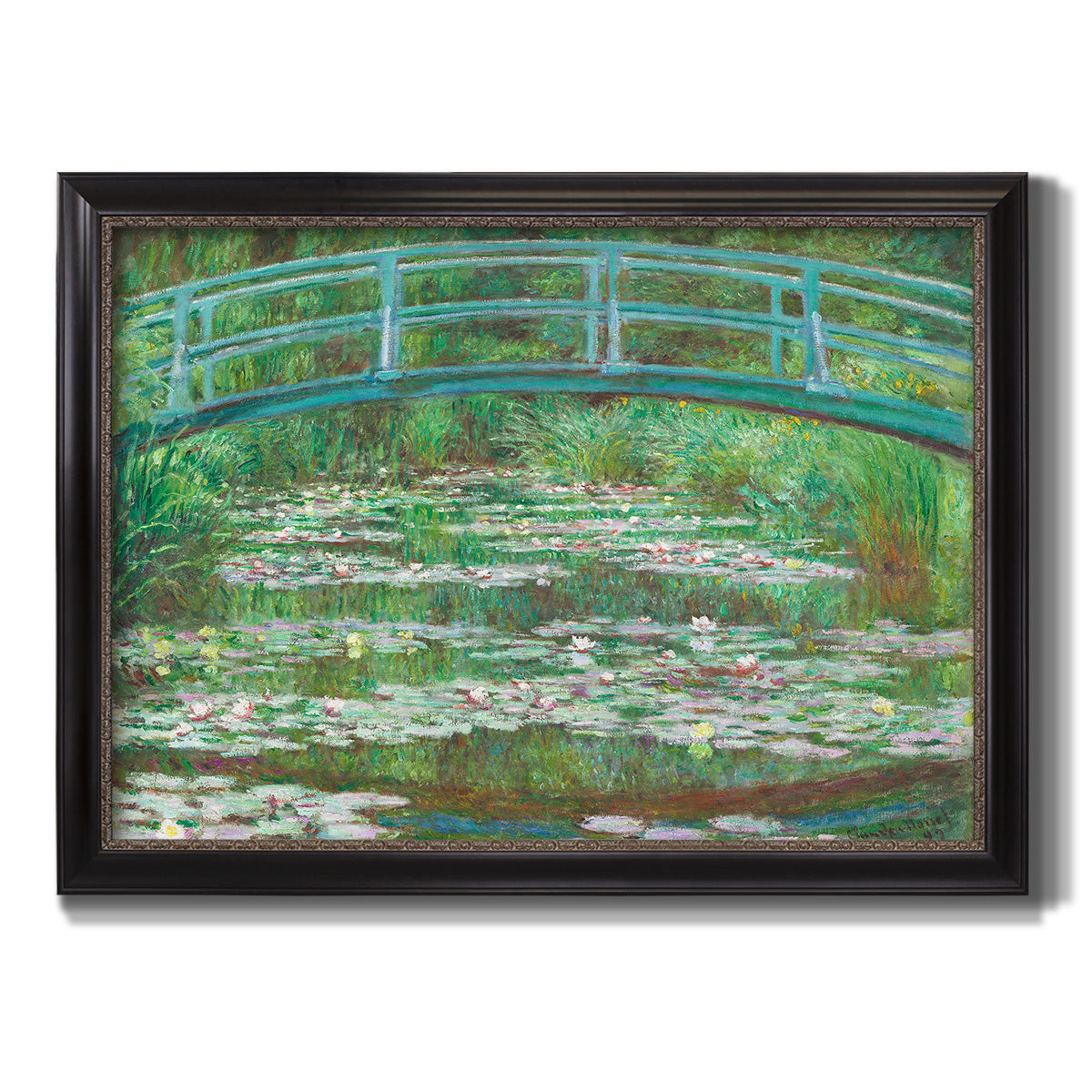Impressionist garden scene with Japanese bridge and water lilies by Claude Monet printed on canvas in an ornate black frame with gilded inner detail.