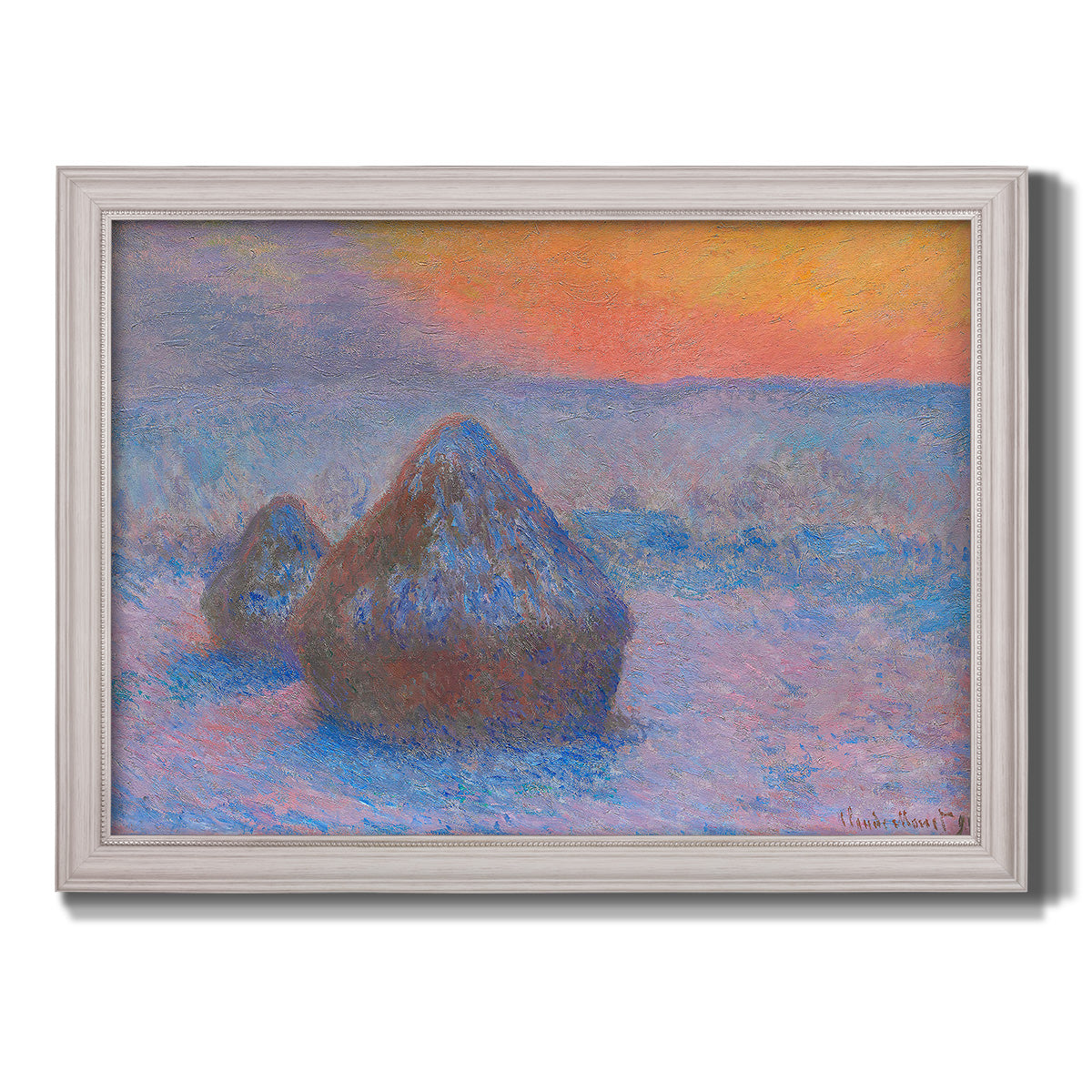 Impressionist haystack scene at sunset by Claude Monet printed on canvas in an ornate weathered white frame.