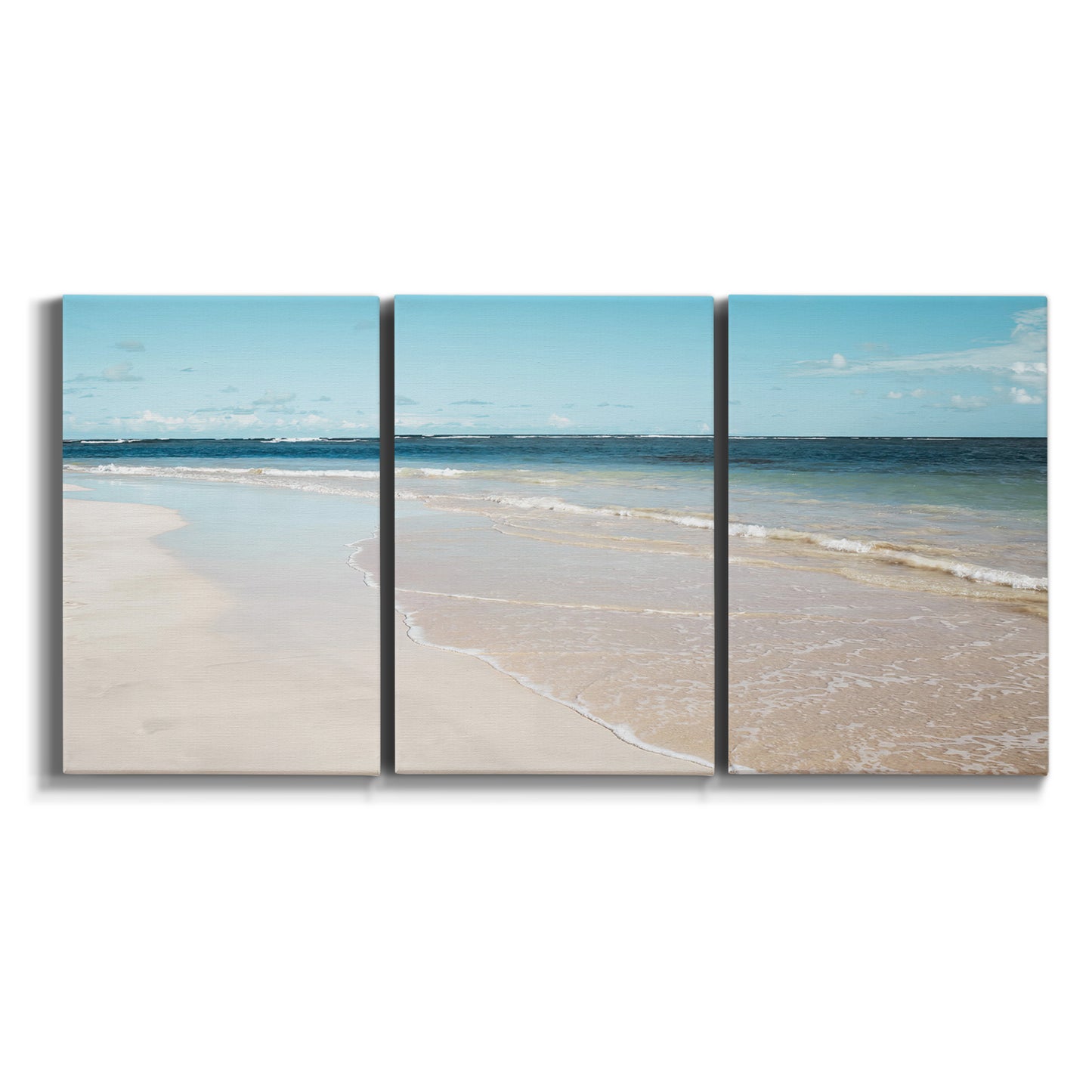 Three-panel canvas wall art featuring white sand beach with gentle waves on white background.