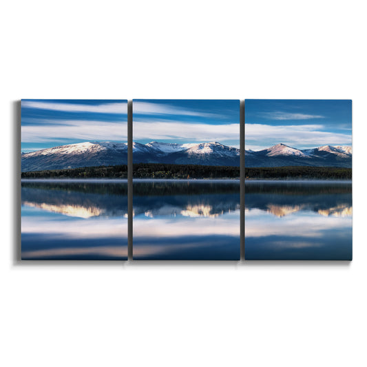 Three-panel canvas wall art featuring calm lake beneath mountains photograph on white background.