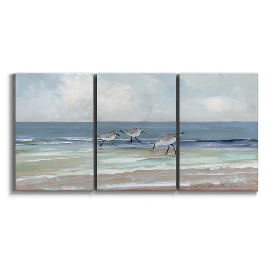 Three-panel canvas wall art featuring shore birds searching along beach on white background.