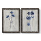 Set of two black barnwood framed canvas prints featuring two rustic monochrome botanical paintings featuring blue wildflower stems on weathered neutral paper.